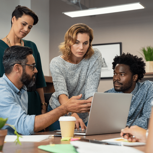 Team collaborating around a laptop